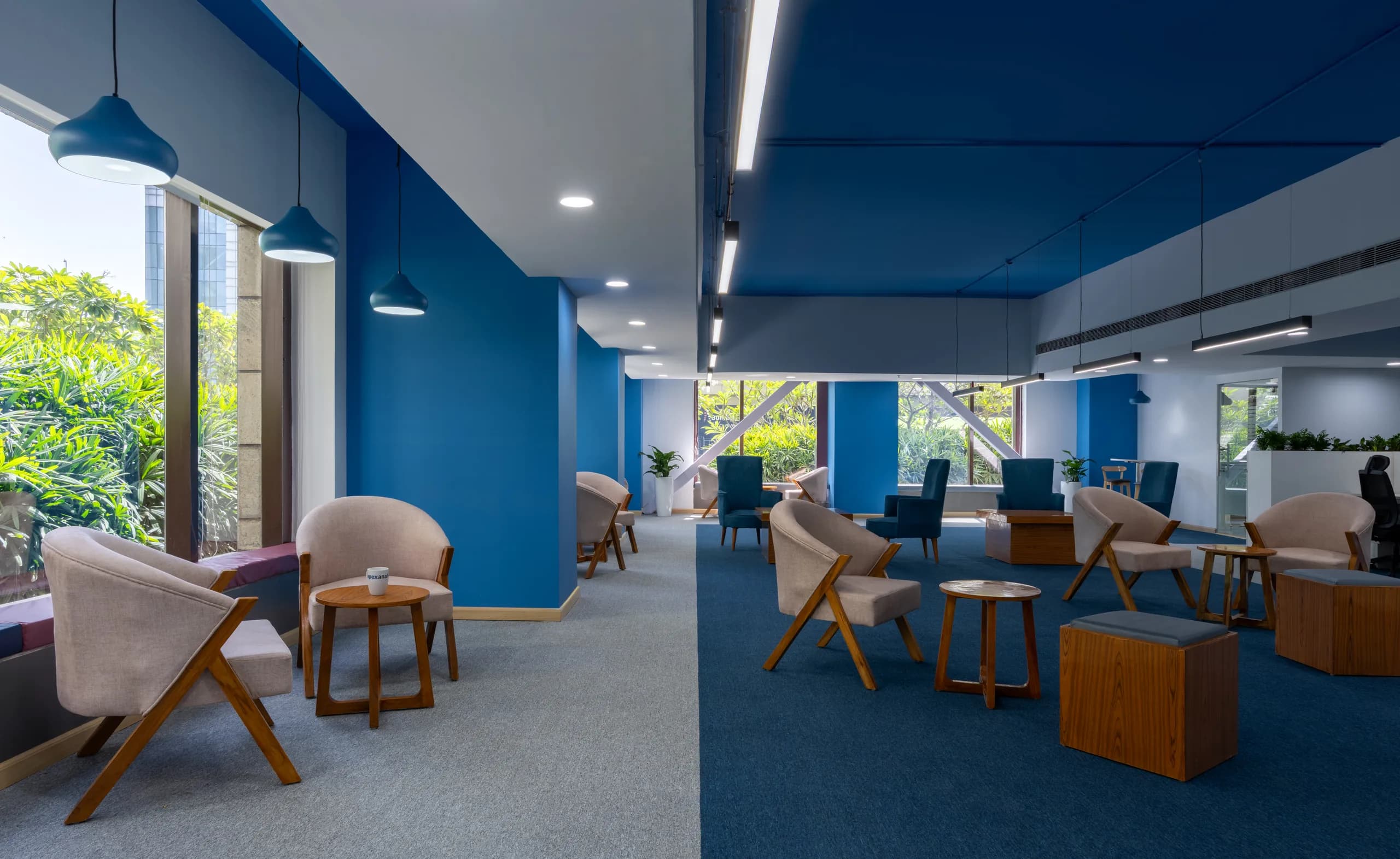 Cafe and breakout lounge with timber chairs beside garden windows, Blue Grid Workspace